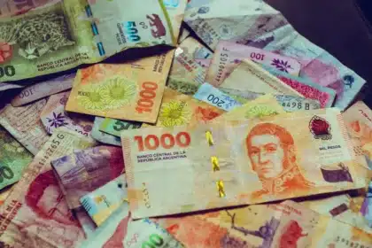 Escritorio de cambio con billetes en pesos y dólares, calculadora y gráficos financieros
