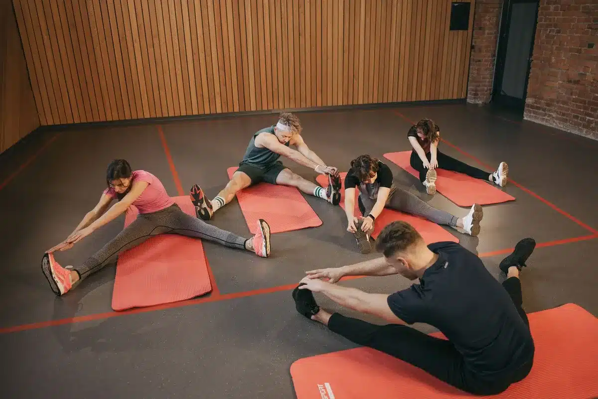 Clase grupal de ejercicio en un gimnasio con participantes realizando actividad física juntos