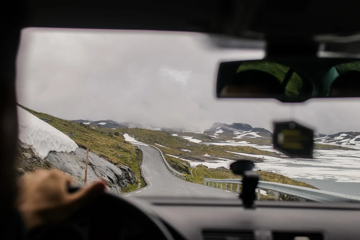 Ruta cordillerana cubierta de nieve y hielo con visibilidad limitada por ventisca