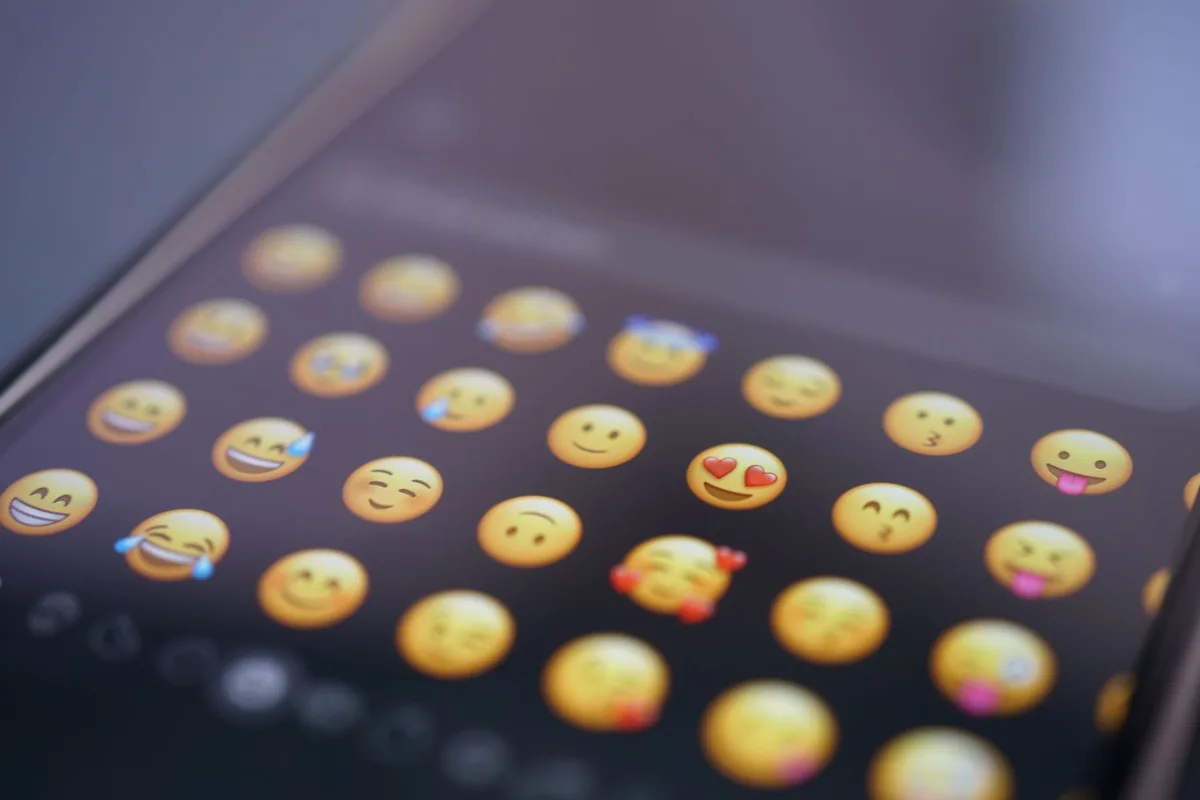Pantalla de tel&eacute;fono mostrando emoticones y mensajes de texto abreviados