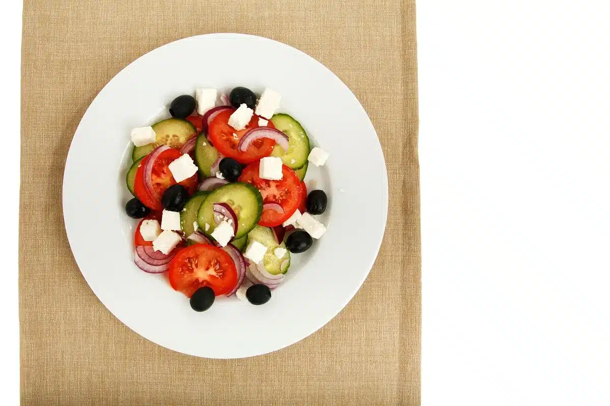 Plato con ensalada, aceite de oliva y pan integral que ilustra la dieta mediterránea