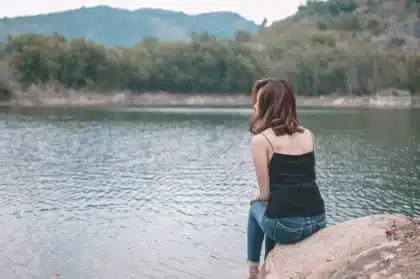 Persona sentada en soledad, mirando hacia adentro en un momento de reflexión y calma