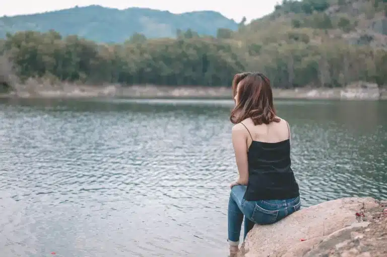 Persona sentada en soledad, mirando hacia adentro en un momento de reflexión y calma