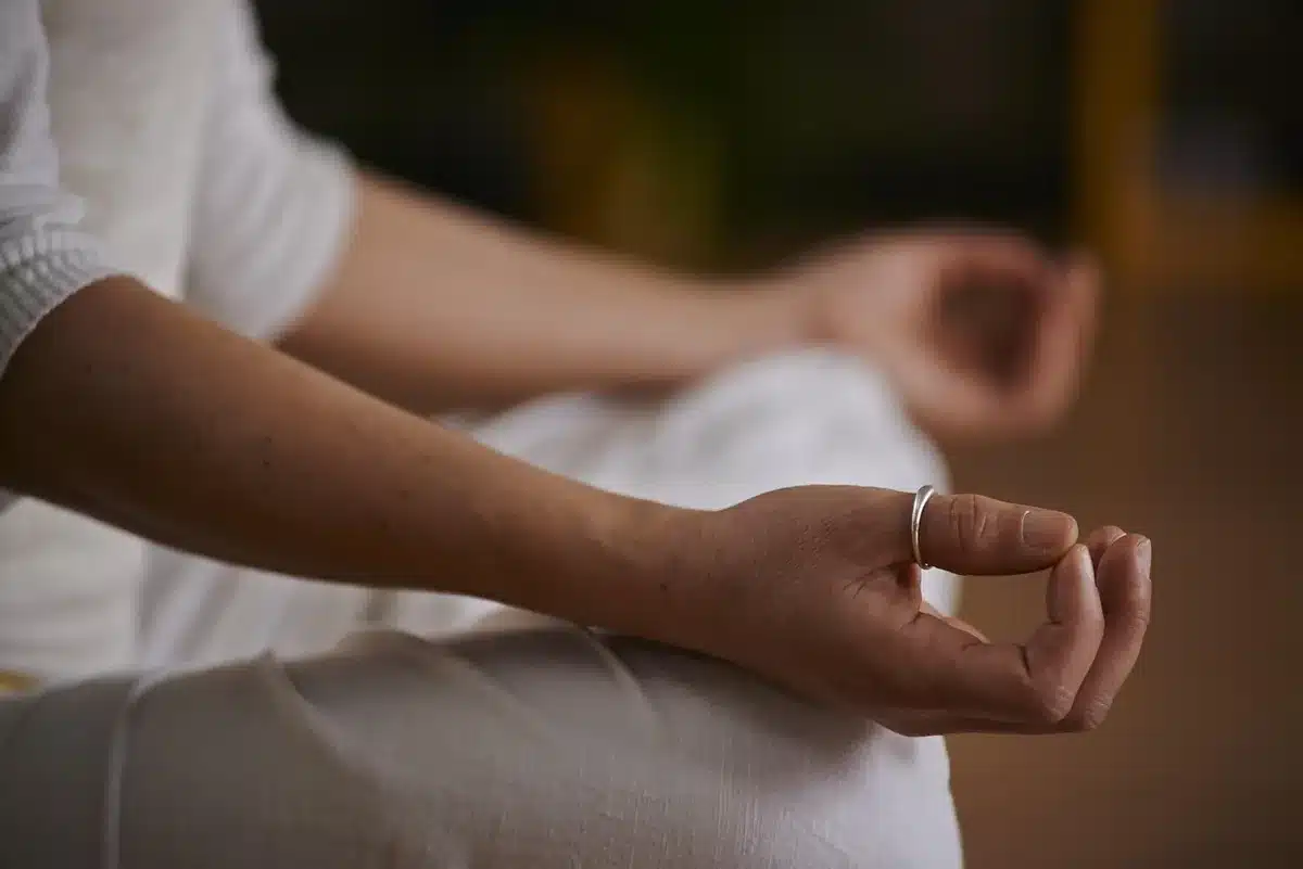 Persona practicando gratitud y meditación en la mañana, escribiendo en un diario.