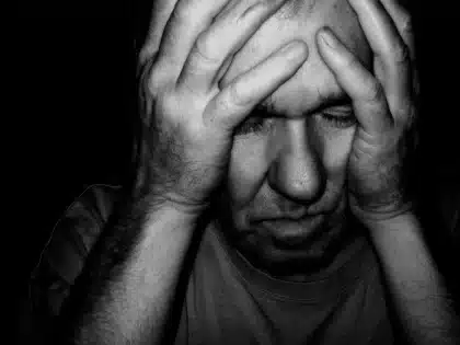 Figura anónima en luz suave con pensamientos negativos disipándose, simbolizando la liberación del ego.